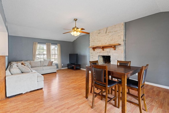 3605 Rushing Blvd, Corpus Christi, TX 78410 - dining area featuring vaulted ceiling, a ceiling fan, light wood-type flooring, a stone fireplace, and baseboards