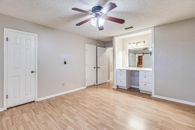 10502 Hemlock Rd, Corpus Christi, TX 78410 - unfurnished bedroom with light wood-style flooring, a textured ceiling, a ceiling fan, and a desk