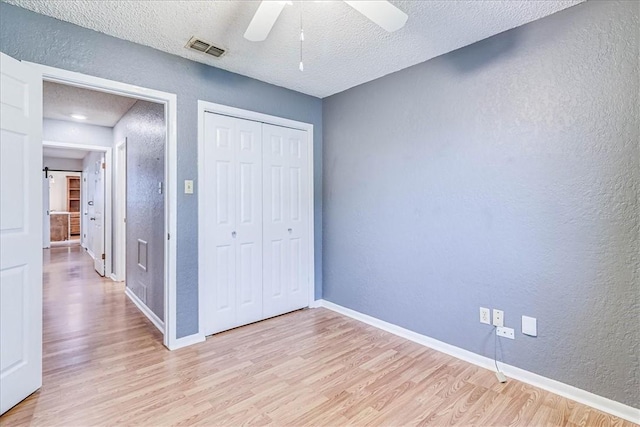 10502 Hemlock Rd, Corpus Christi, TX 78410 - unfurnished bedroom with a textured wall, light wood-style floors, a textured ceiling, a closet, and a ceiling fan