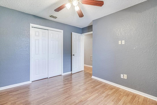 10502 Hemlock Rd, Corpus Christi, TX 78410 - unfurnished bedroom with a textured wall, light wood finished floors, a textured ceiling, a closet, and a ceiling fan