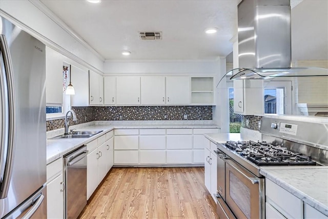 10502 Hemlock Rd, Corpus Christi, TX 78410 - kitchen with stainless steel appliances, island range hood, open shelves, light wood-type flooring, and light countertops