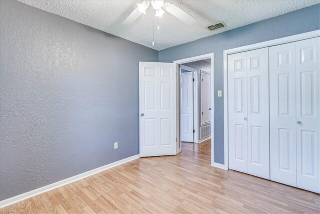 10502 Hemlock Rd, Corpus Christi, TX 78410 - unfurnished bedroom featuring a textured wall, light wood-type flooring, a textured ceiling, a closet, and a ceiling fan