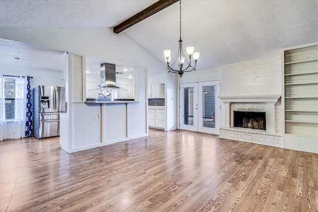 10502 Hemlock Rd, Corpus Christi, TX 78410 - unfurnished living room with a chandelier, wood finished floors, and a brick fireplace