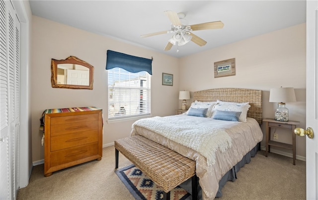 bedroom featuring baseboards, light colored carpet, and a ceiling fan