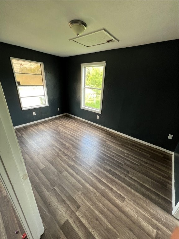 unfurnished room with dark wood-type flooring