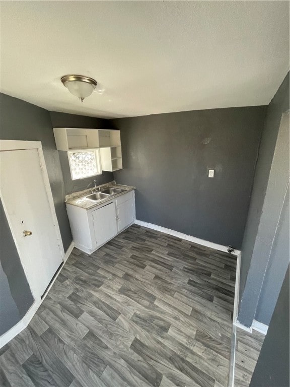 laundry room featuring sink and dark hardwood / wood-style floors