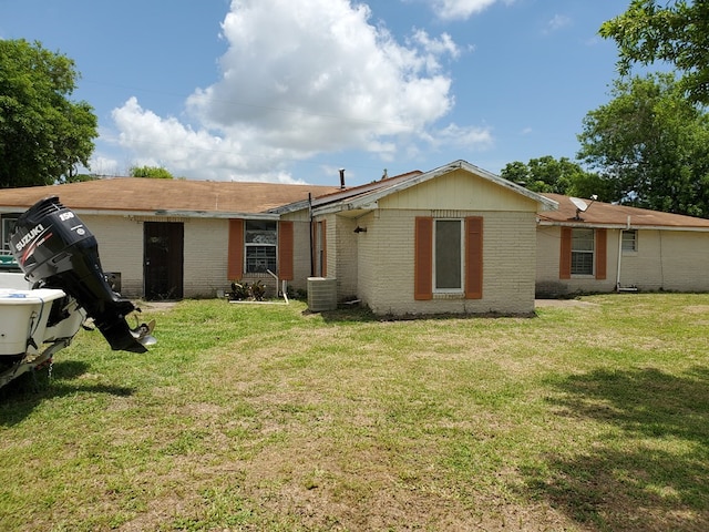 back of property featuring a lawn and central air condition unit