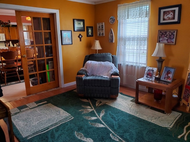 living area featuring crown molding and hardwood / wood-style floors