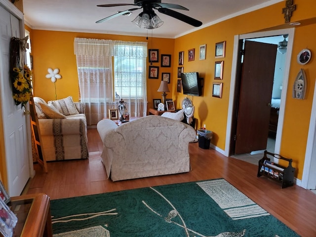 living room with hardwood / wood-style flooring, ceiling fan, and ornamental molding