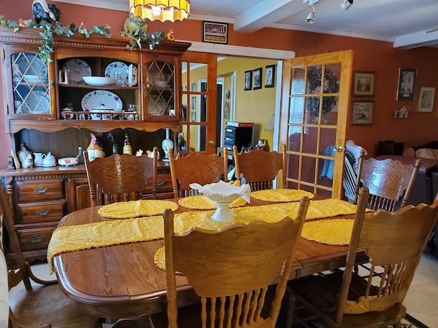 dining space featuring beamed ceiling, tile patterned flooring, and crown molding