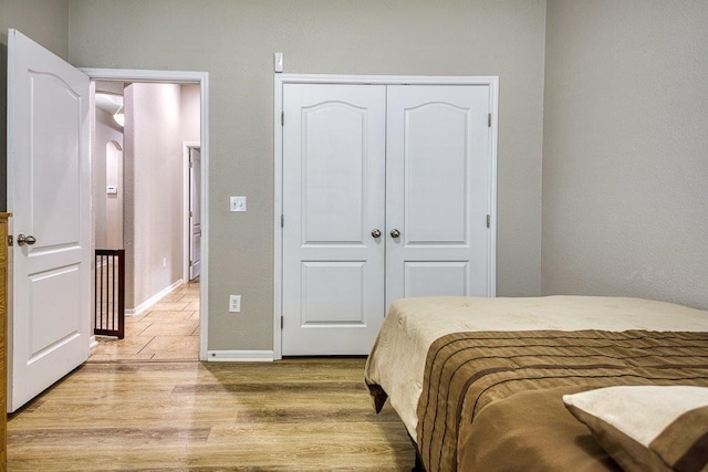 bedroom featuring a closet, baseboards, and wood finished floors