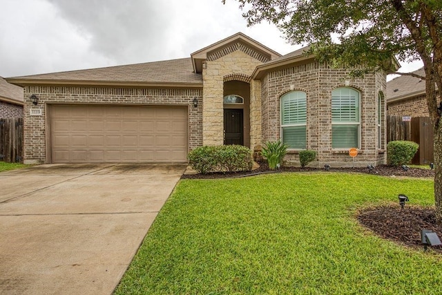 view of front of home with brick siding, an attached garage, a front yard, fence, and driveway