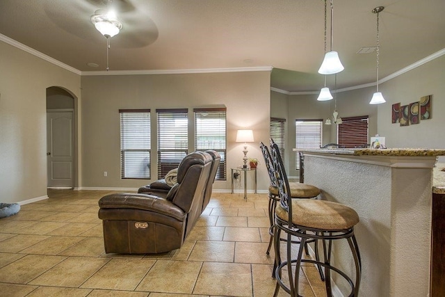 kitchen with arched walkways, a breakfast bar, visible vents, and baseboards