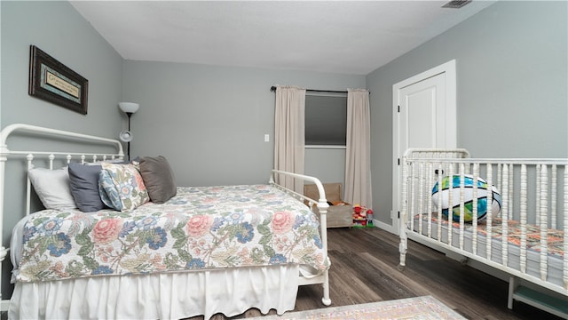 bedroom with dark hardwood / wood-style flooring