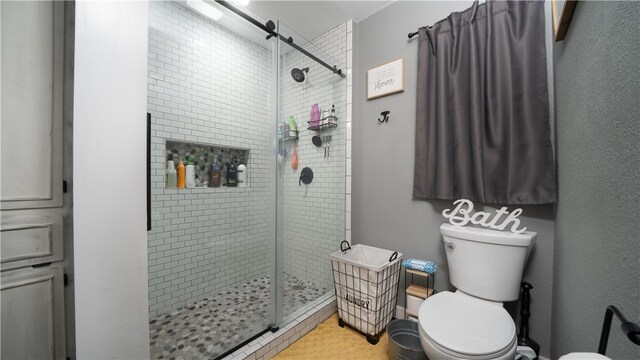 bathroom with toilet and an enclosed shower