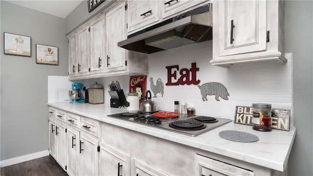 kitchen with stainless steel gas cooktop, dark hardwood / wood-style flooring, backsplash, and light stone countertops