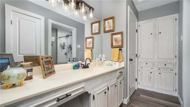 bathroom with hardwood / wood-style floors, vanity, and a shower