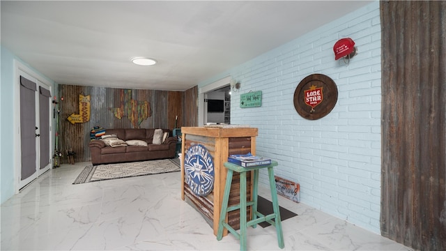 living room featuring wood walls and brick wall