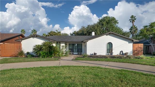 single story home featuring a front lawn