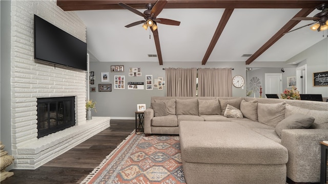 living room featuring ceiling fan, vaulted ceiling with beams, dark hardwood / wood-style floors, and a brick fireplace