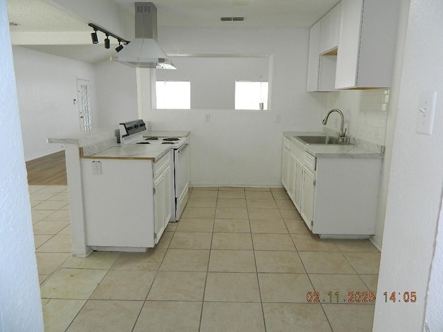 kitchen featuring white electric stove, white cabinetry, sink, island exhaust hood, and kitchen peninsula