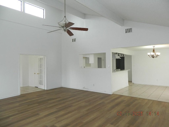 unfurnished living room with hardwood / wood-style flooring, high vaulted ceiling, ceiling fan with notable chandelier, and beam ceiling