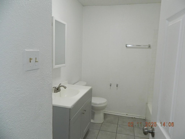 bathroom featuring vanity, toilet, tile patterned flooring, and a tub