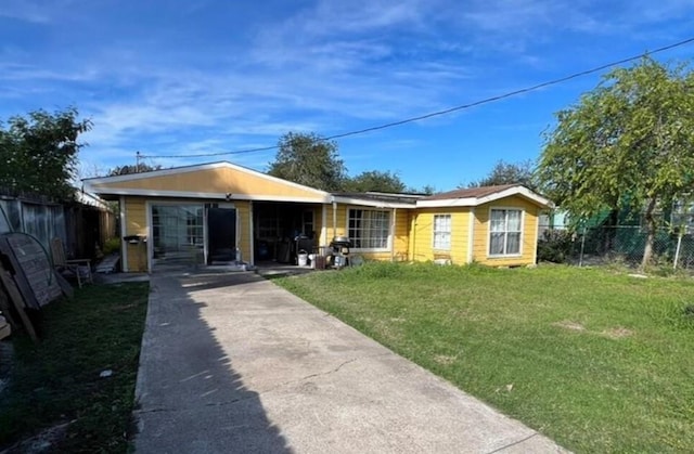 bungalow-style house featuring driveway, fence, and a front lawn