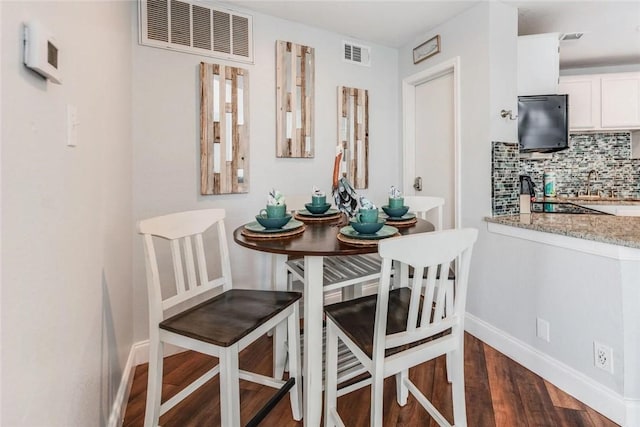 dining space featuring dark hardwood / wood-style floors and sink