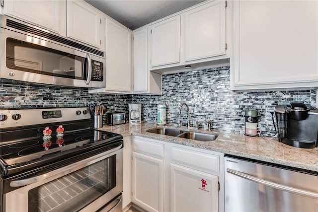 kitchen featuring white cabinets, stainless steel appliances, tasteful backsplash, and sink