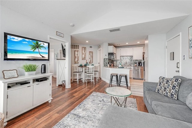 living room featuring dark hardwood / wood-style flooring and lofted ceiling