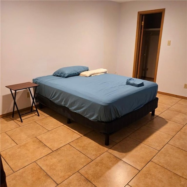 bedroom with light tile patterned floors and baseboards