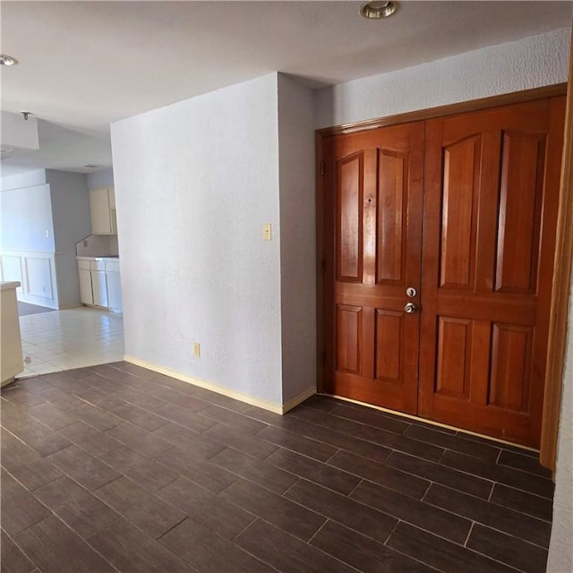 entryway featuring wood tiled floor and a textured wall