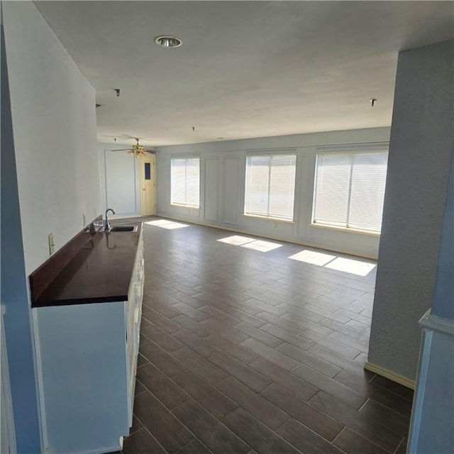 unfurnished living room with dark wood-style floors and a sink