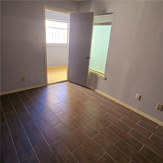 spare room featuring baseboards and wood finish floors