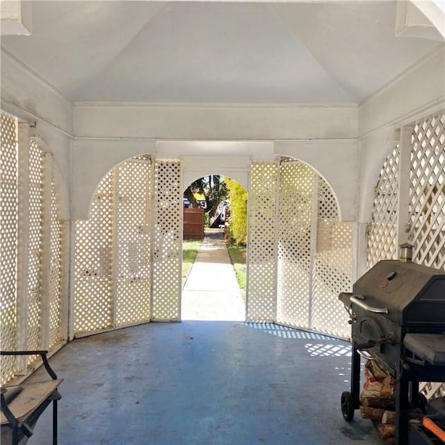 interior space featuring vaulted ceiling and concrete flooring