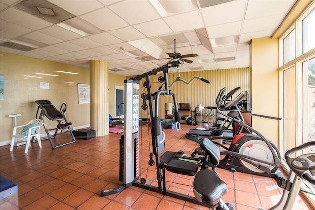 gym with a drop ceiling, tile patterned floors, and ceiling fan