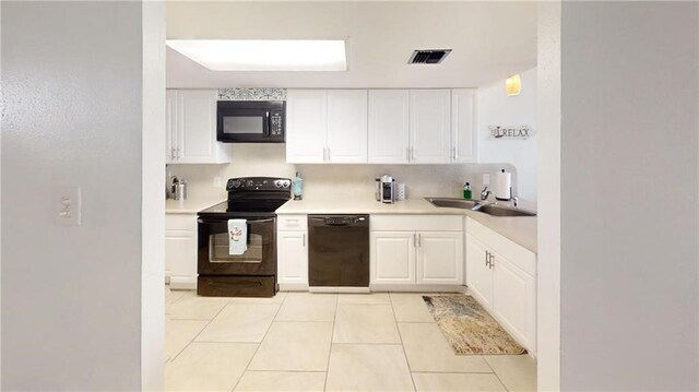 kitchen with black appliances, sink, light tile patterned flooring, and white cabinets