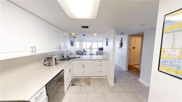 kitchen with dishwasher, kitchen peninsula, white cabinets, sink, and light tile patterned floors