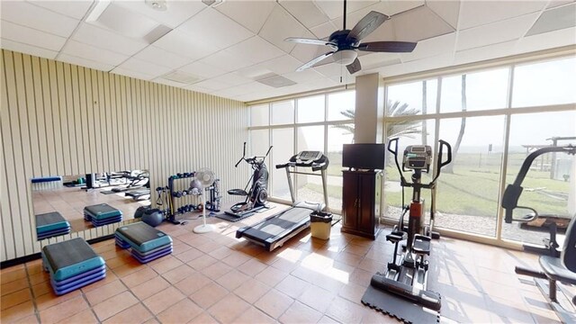 workout area featuring ceiling fan, tile patterned flooring, and a drop ceiling