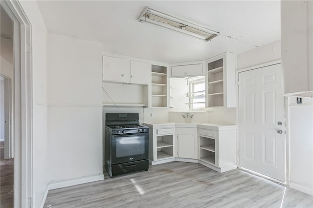 kitchen featuring black gas range, light hardwood / wood-style floors, and white cabinets