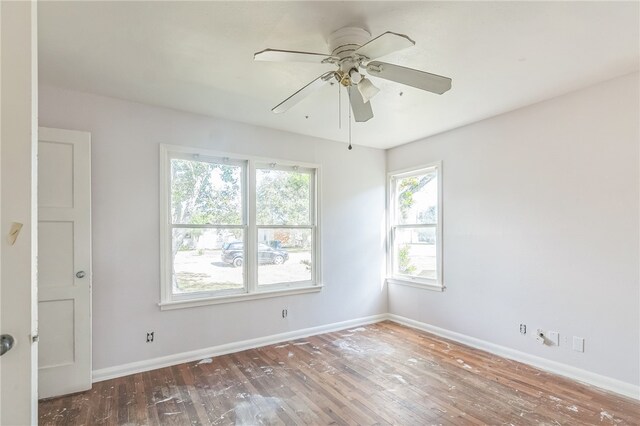 unfurnished room featuring dark hardwood / wood-style flooring, a wealth of natural light, and ceiling fan