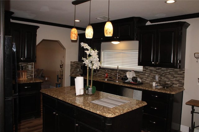 kitchen with pendant lighting, sink, tasteful backsplash, and a kitchen island