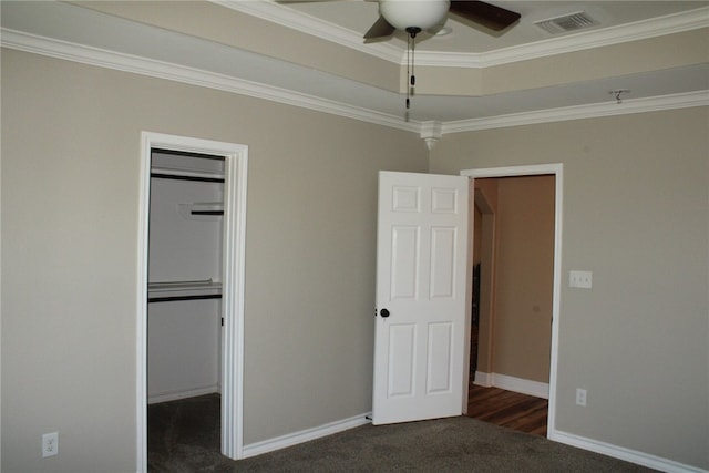 unfurnished bedroom featuring dark colored carpet, ornamental molding, and a closet