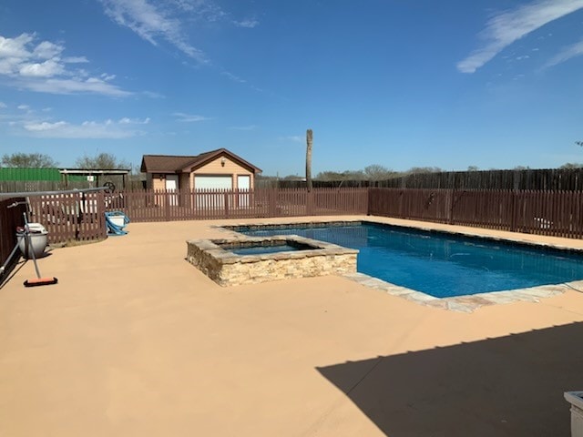 view of pool featuring a patio and an in ground hot tub