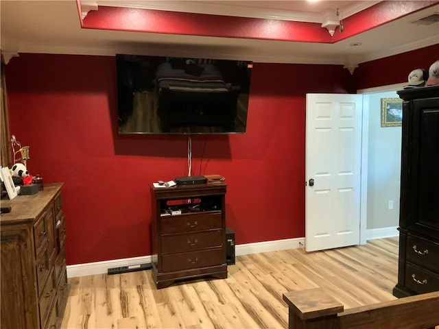 living room with a tray ceiling, light hardwood / wood-style flooring, and ornamental molding