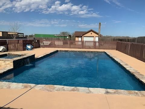 view of pool with a patio area and an in ground hot tub