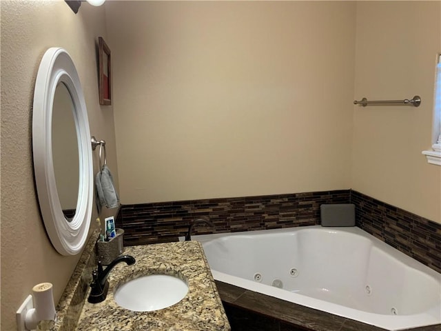 bathroom featuring a relaxing tiled tub and vanity