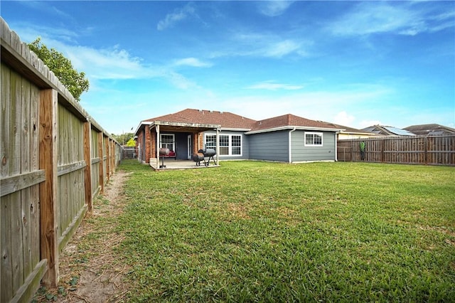 2401 Handlin Dr, Corpus Christi, TX 78418 - rear view of house with a patio, a fenced backyard, and a yard