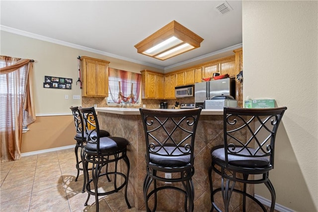 2401 Handlin Dr, Corpus Christi, TX 78418 - kitchen featuring tasteful backsplash, a breakfast bar area, stainless steel appliances, and visible vents